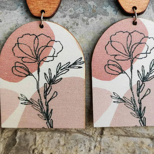 Botanical arch wood earrings in dusty pink with floral line art and abstract shapes.