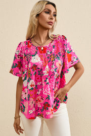 Hot pink floral smocked yoke flutter sleeve blouse with a relaxed fit.