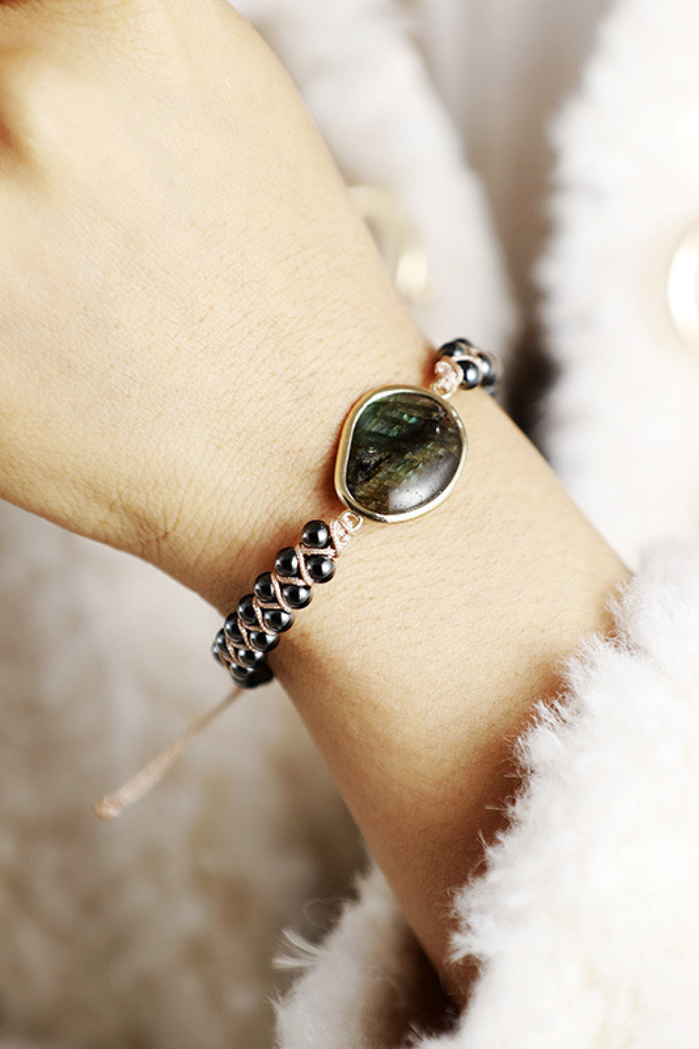 Black beaded bracelet with labradorite stone and braided detail.