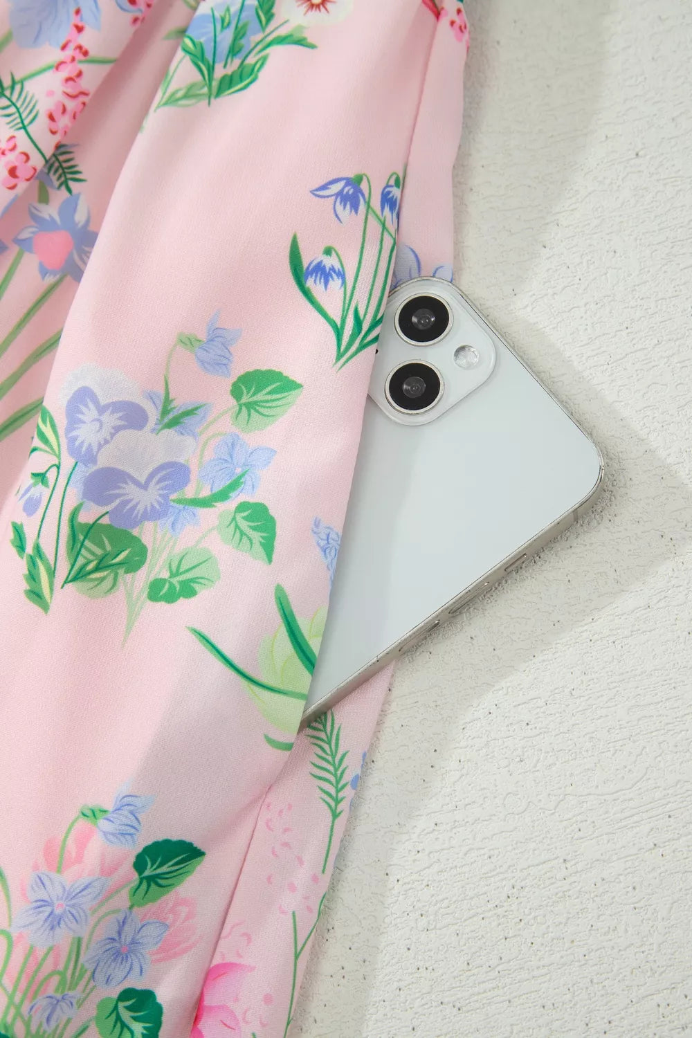 Pink midi dress with a wildflower print, showing a phone in the pocket.