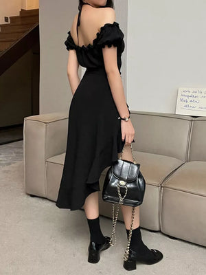 Black asymmetrical ruffle hem off-shoulder dress with halter neck and flowing skirt.