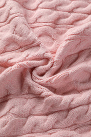Blush pink cable knit sweater with a textured weave.