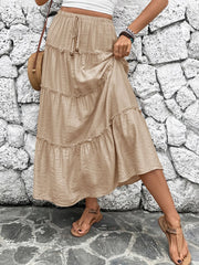 Tiered maxi skirt in tan with drawstring waist and ruffled tiers.