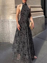 Black polka dot halter maxi dress with a flowy skirt and high neckline.