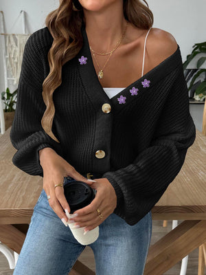 Black balloon sleeve cardigan with floral embellishments and buttons.