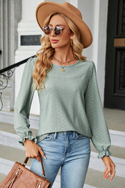 Light Green textured puff sleeve blouse with ruffled cuffs and crew neck, styled with jeans.