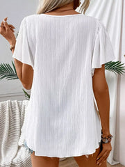 White embroidered square neck flutter blouse with textured fabric.