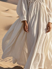 White crochet lace V-neck midi dress with long sleeves and flowing skirt.
