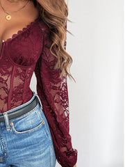 Burgundy lace bodysuit with long sleeves and corset detailing, styled with jeans.