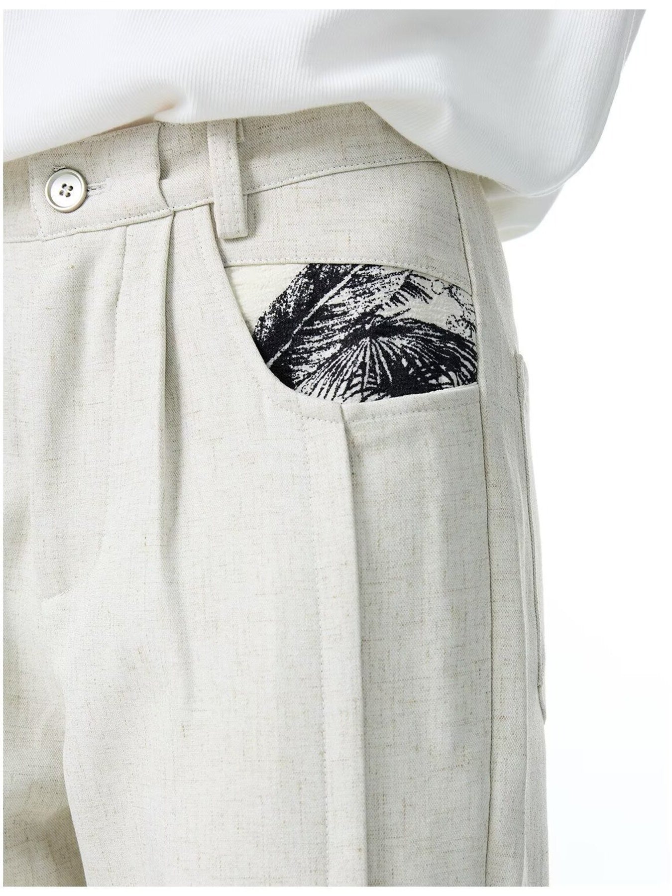 Men's ivory wide-leg trousers with a black palm leaf pocket detail.