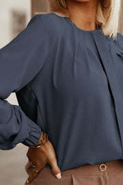 Misty Blue pleated yoke blouse with button detail and long sleeves.