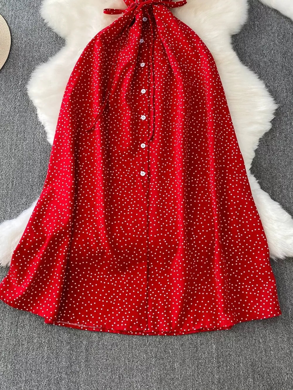 Red polka dot maxi dress with button front and tie neck detail.