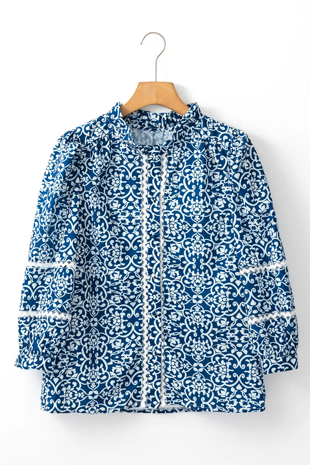 Peacock blue medallion print poet blouse with white lace trim and ruffled neckline.