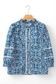 Peacock blue medallion print poet blouse with white lace trim and ruffled neckline.