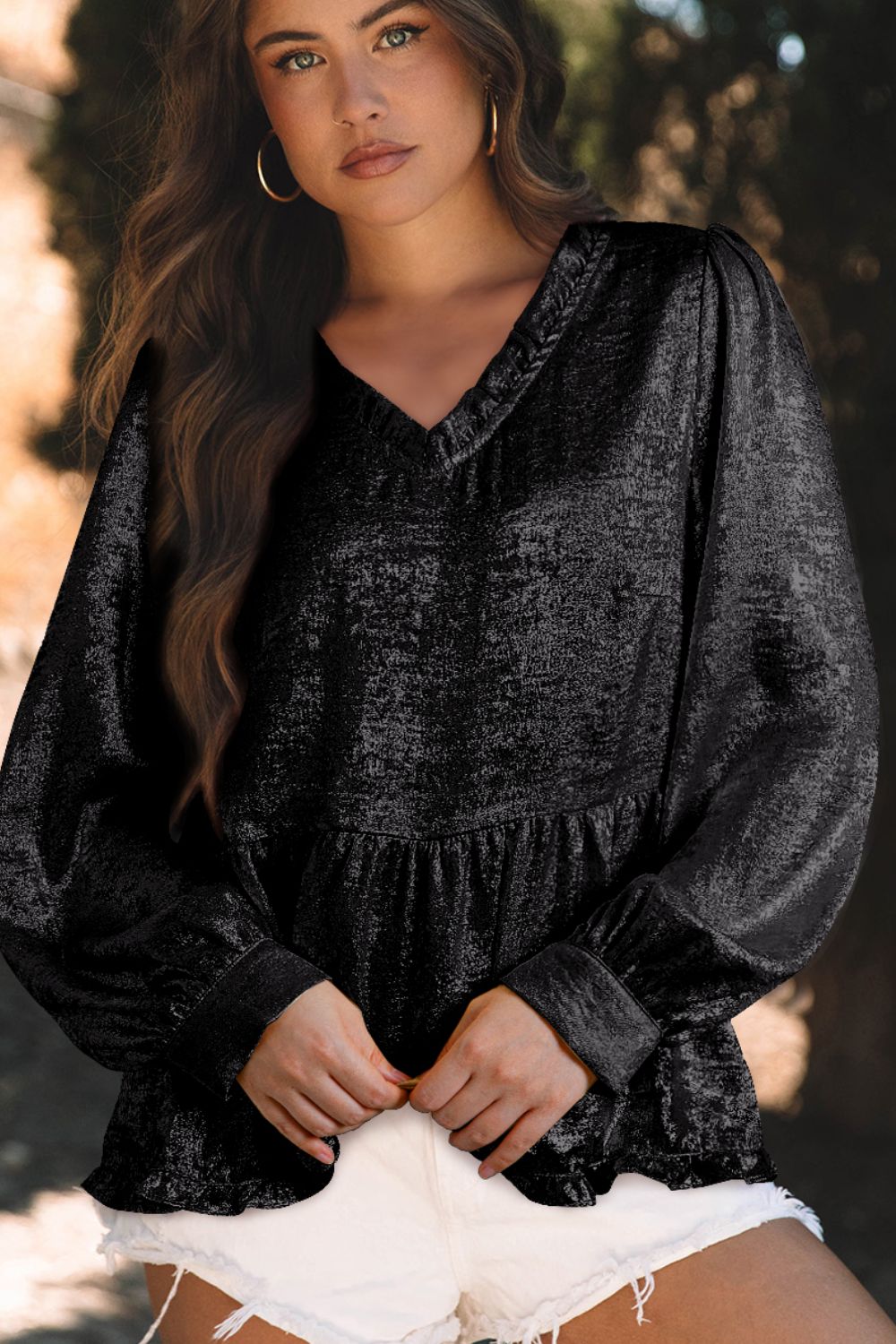 Black metallic blouse with v-neck, gathered waist, and long gathered sleeves.