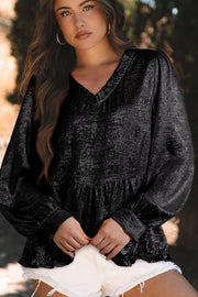 Black metallic blouse with v-neck, gathered waist, and long gathered sleeves.