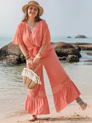 Coral viscose jumpsuit with lace sleeves and hem, tie-front, V-neck, and button detail.