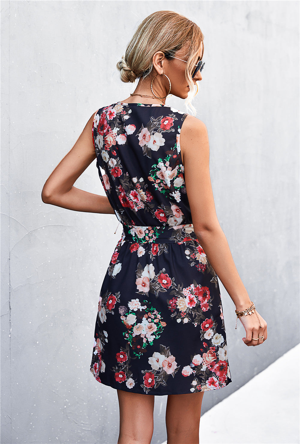 Black floral zip-front mini dress with tie waist and sleeveless design