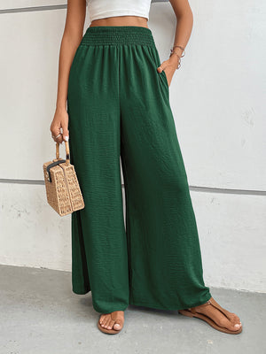 Textured palazzo lounge trousers in dark green with smocked waist and wide legs.
