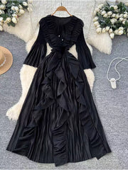 Black brocade a-line midi dress with cascading ruffles and bell sleeves.