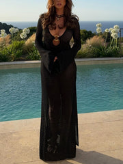 Black knit maxi dress with keyhole neckline, gold ring detail, and bell sleeves.