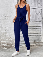 Dark blue chain-strap gathered waist jumpsuit with tie belt and pockets.