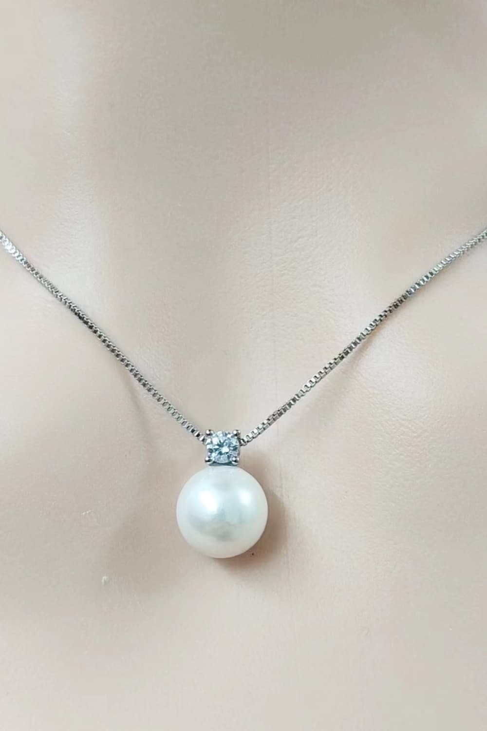 Solitaire pearl pendant necklace in silver with a cubic zirconia accent on a delicate chain.