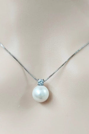 Solitaire pearl pendant necklace in silver with a cubic zirconia accent on a delicate chain.