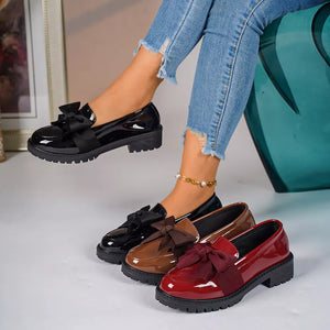 Chic patent loafers with bow detail in black, brown, and burgundy.