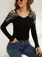 Black ribbed knit blouse with strappy cold shoulder and rhinestone embellishments.