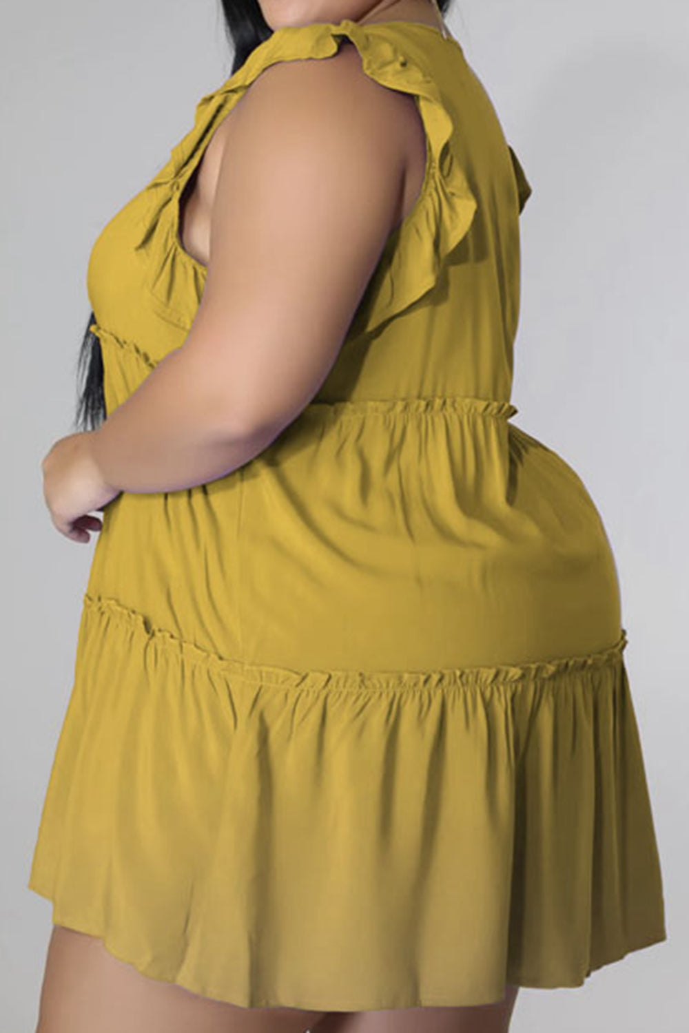 Tiered ruffle babydoll mini dress in mustard yellow with ruffled tiers and elastic waist.