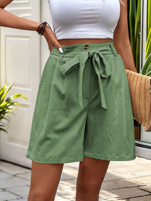 Matcha green pleated linen tie-waist bermuda shorts with button detail.