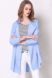 Light blue drape-front trench coat with shoulder detailing and buttoned cuffs.