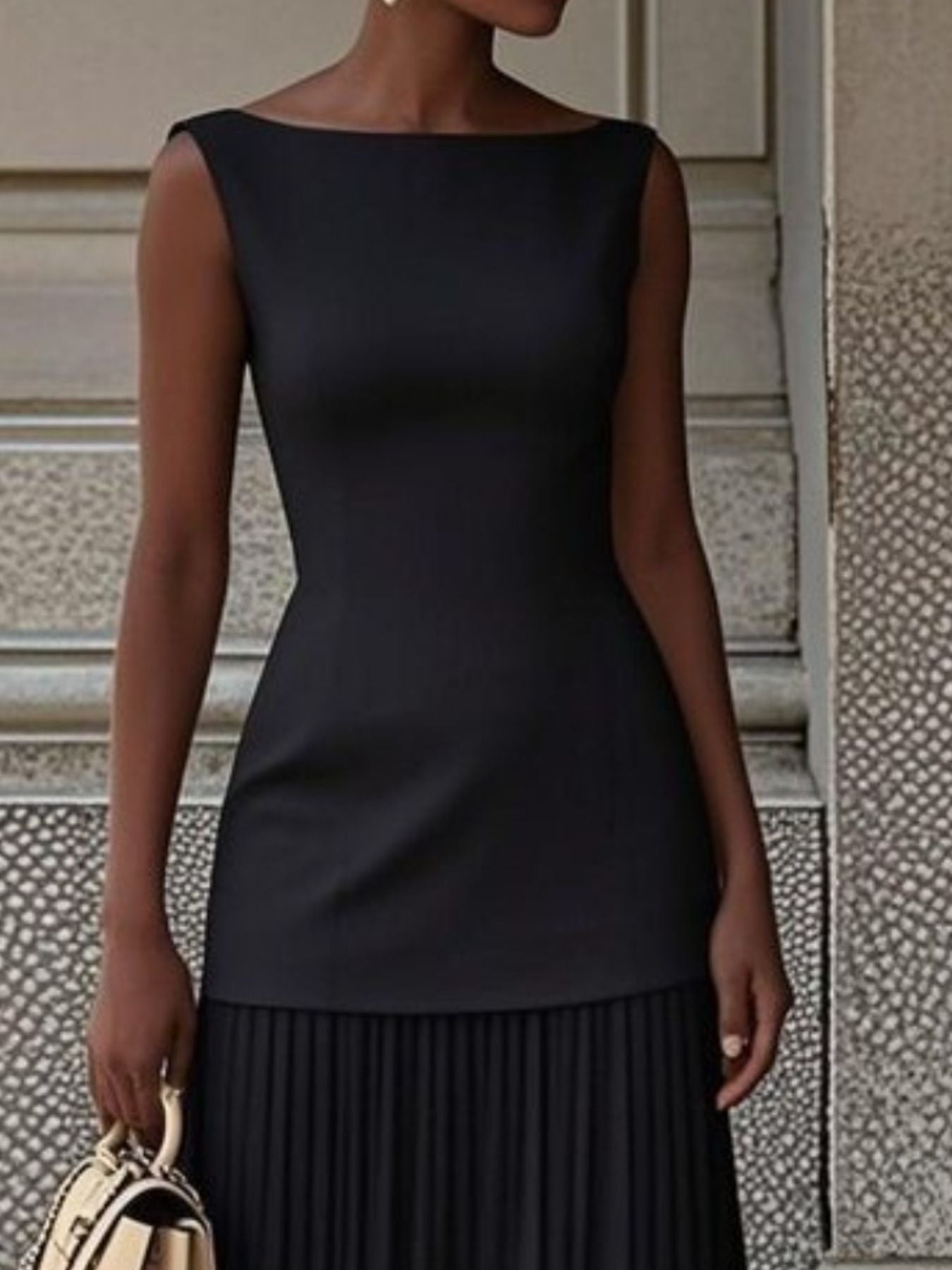 Black boat neck sleeveless maxi dress with pleated skirt detail.