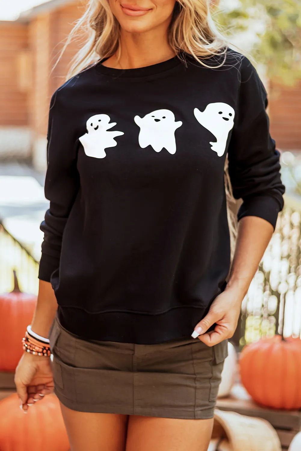 Black crewneck sweatshirt with a spooky trio of white ghost graphics.