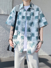 Men's abstract print short sleeve button-down shirt in white with teal accents.