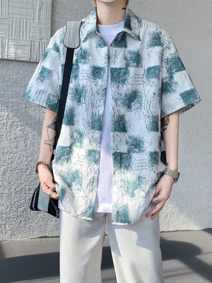 Men's abstract print short sleeve button-down shirt in white with teal accents.