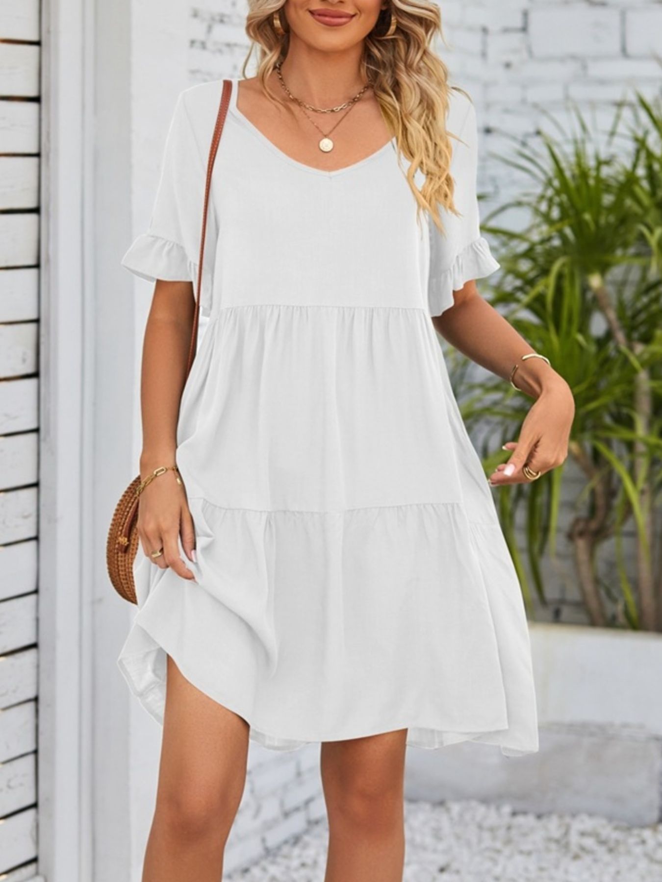 White ruffled sleeve mini dress with tiered skirt and V-neck.