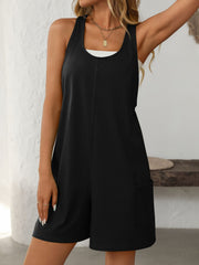 Black sleeveless utility romper with seam details and patch pockets.
