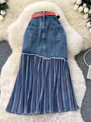 Patchwork denim midi skirt with red and white striped pleated hem and orange belt.