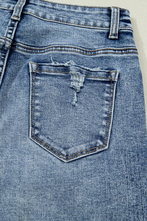 Light wash denim maternity jeans with distressed pocket detail and relaxed fit.