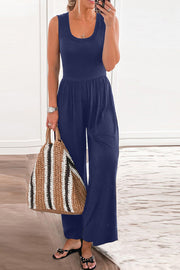 Navy gathered waist wide leg jumpsuit with scoop neck and sleeveless design.