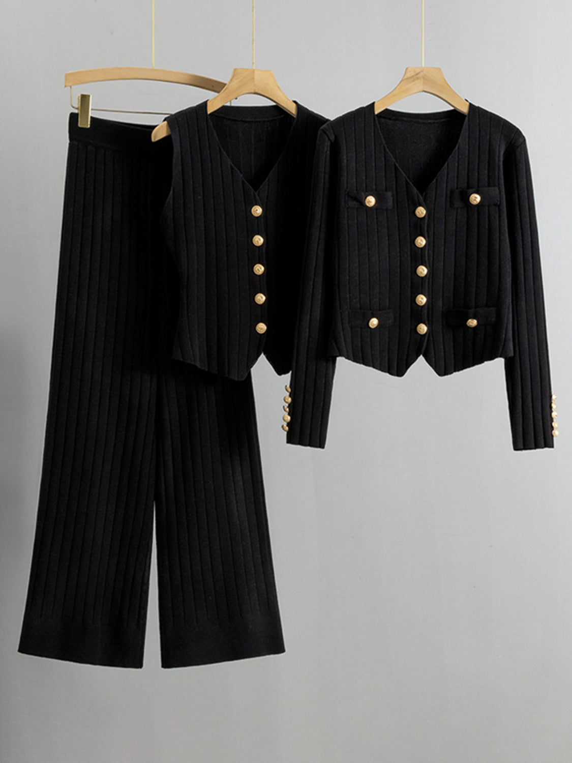 Black ribbed knit outfit set with gold buttons, featuring a cardigan and wide-leg pants.