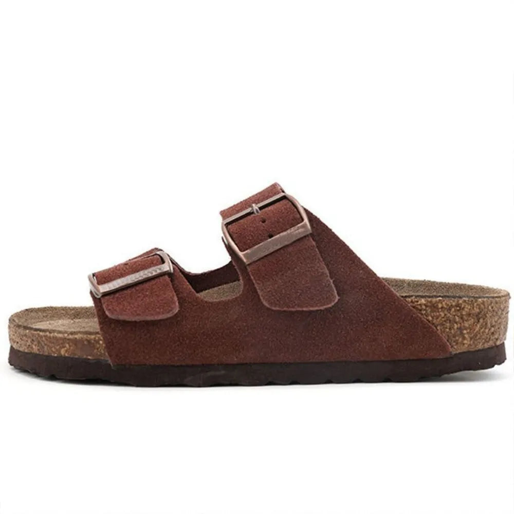 Dark brown suede slide sandals with two adjustable buckle straps and cork footbed.