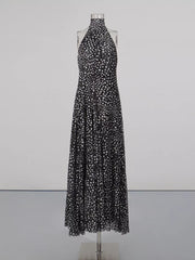 Black and white polka dot halter maxi dress with a flowing skirt.