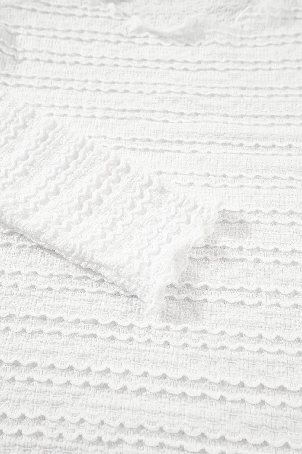 White textured long sleeve top with ruffle trim detail