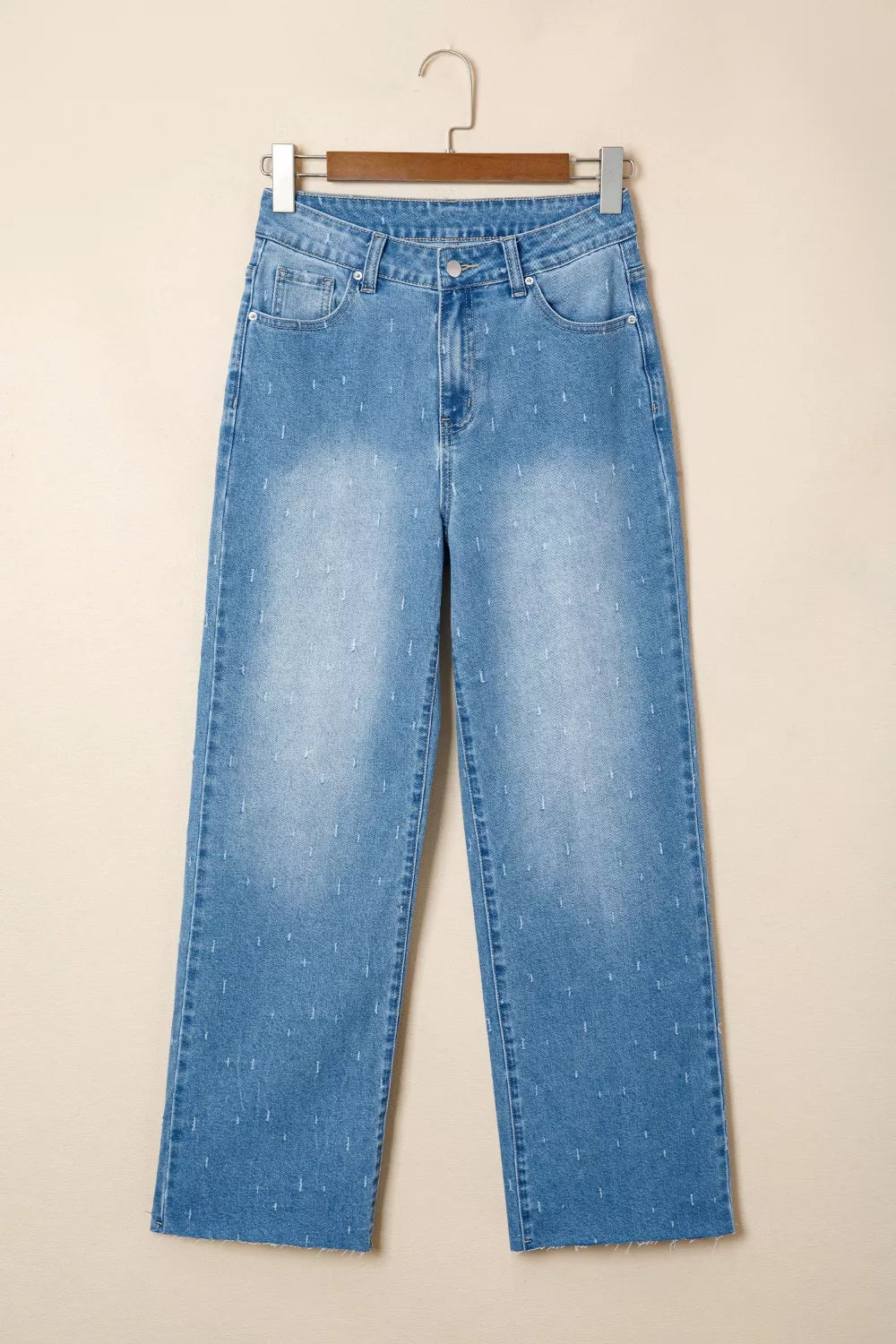 High-rise light wash denim jeans with subtle white stitch detail and raw hem.
