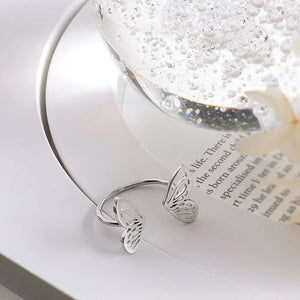 Silver butterfly wing open-ended ring with intricate cut-out details.