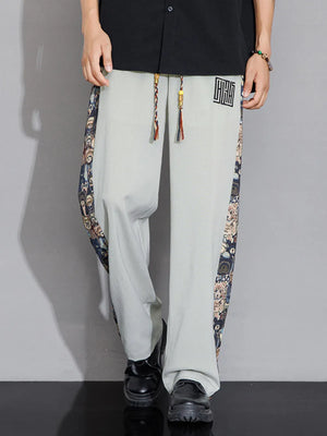 Men's light gray sweatpants with printed side stripes and drawstring.