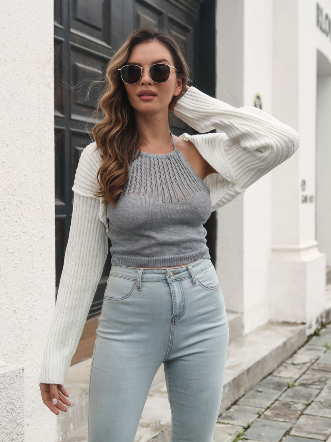 White acrylic knit bolero with shrug sleeves, worn over a grey halter top.